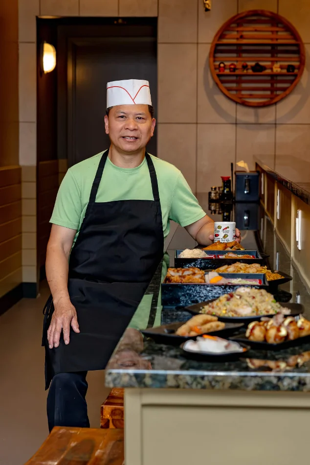 A chef at Momiji beside a counter of freshly plated dishes